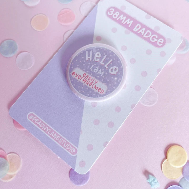 38mm badge with 'Hello, I am easily overwhelmed' text on a polka dot card with confetti on a pink background